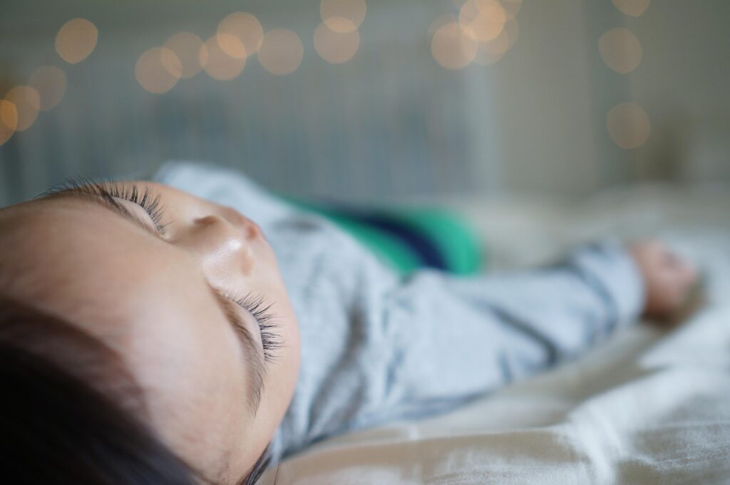 Baby sleeping with arms free after parents learn when to stop swaddling